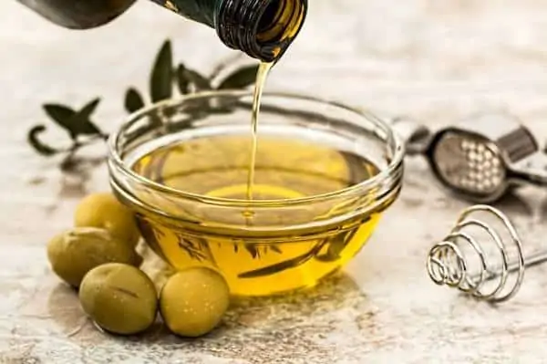 image of extra virgin olive oil pouring out of a glass