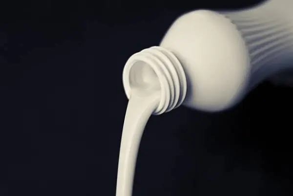 milk pouring out of a glass