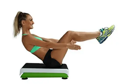 a fit woman doing abdominal exercises on a small whole body vibration machine. 